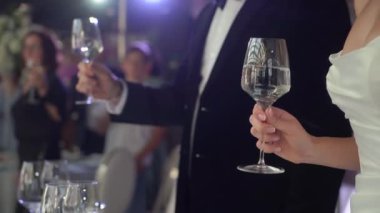 Partide insanlar bardakları alkolle tokuşturur. Şampanya ya da köpüklü şarap içer. Gelin ve damat çifti içecek ister..