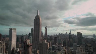 Empire State Binası 'nın çarpıcı ve dramatik manzarası kasvetli, bulutlu New York şehrinin siluetinin ortasında dikiliyor.