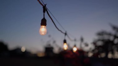 Işıl ışıl parlayan sicim ışıklarının yakın görüntüsü alacakaranlık gökyüzünü güzelce aydınlatıyor, hem sıcaklığı hem de huzuru çağrıştırıyor.