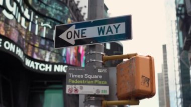 NEW YORK, ABD - 10 Nisan 2024: Tasvirde New York City 'deki Times Meydanı' nın canlı enerjisi, tek yönlü sokak tabelası ve Times Meydanı Pedestrian Plaza tabelalarıyla şehir manzarasına karşı gösteriliyor