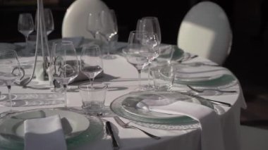 Gözlüklü ve tabaklı bir düğün resepsiyonu için masa ayarlama. Kapalı resepsiyon salonu.