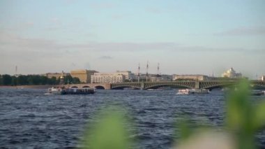 Küçük bir tekne, güneşli bir günde huzurlu ve sakin bir su yolunda yol alır. Saint-Petersburg 'da sakin bir manzara yaratır.