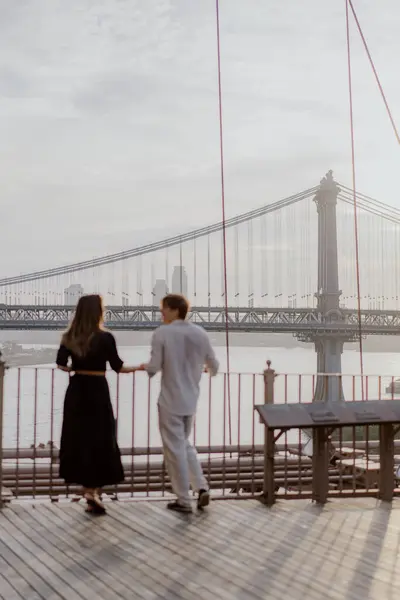 Çok güzel romantik bir an, çarpıcı bir köprü zemininin çerçevelediği sevimli bir çift arasında çekildi. New York 'ta Manhattan ve Brooklyn Köprüsü.