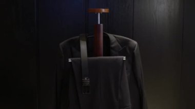Modern bir askıda güzel bir şekilde sergilenen şık siyah takım elbise, moda ve tasarım için ideal.
