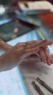 Zarif bir elmas yüzüğü tutan bir elin yakın çekimi, zarif ve çarpıcı tasarımı vurguluyor.