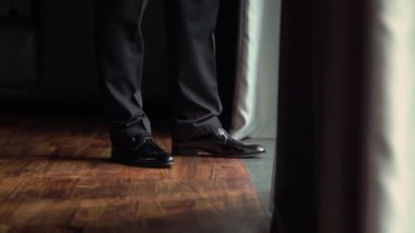 Yakından bakıldığında siyah ayakkabılar şık bir iç mekan ortamında resmi pantolonlarla uyumlu.