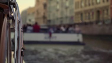 Güzel hazırlanmış bir tekne, canlı binalarla dolu büyüleyici bir kanalda zarifçe yol alır.