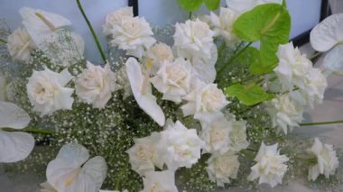 Bu çarpıcı çiçek aranjmanı beyaz güller ve yemyeşil renkler içerir.