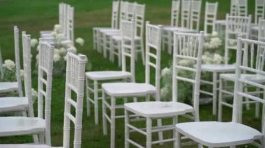 Büyüleyici beyaz sandalyeler yemyeşil bir tarlada güzelce dizilmiş, düğünler ve diğer özel günler için mükemmel.