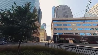 Modern çağdaş binaları, dingin ve davetkar bir patikayla birlikte gösteren canlı bir şehir manzarası.