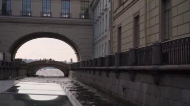 Huzurlu bir kanal boyunca uzanan kemer, sakin ve görkemli bir manzarayla çarpıcı tarihi bir mimariyi vurguluyor. Saint-Petersburg