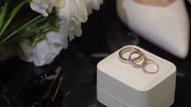 Şık ve zarif beyaz gelinlik aksesuarları, örneğin ayakkabılar, güzel yüzükler ve düğün için büyüleyici buketler.