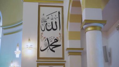 Allah 'ın ve Hz. Muhammed' in camiyi güzelleştirmesinin çarpıcı ve karmaşık bir şekilde tasarlanmış Arapça el yazısı.
