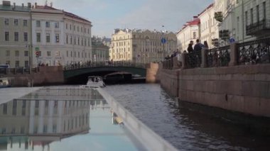 Saint-Petersburg 'daki manzaralı su yolu boyunca uzanan büyüleyici, canlı binalar ve teknelerin manzaralı manzaralı bir kanalı görüntüsü.