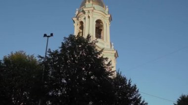 Görkemli bir kilise kulesi yemyeşil bir ortamda zarif bir şekilde yükselir, alacakaranlıkta huzurun özünü güzelce yakalar.