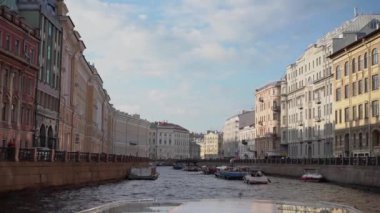 Saint-Petersburg 'daki manzaralı su yolu boyunca canlı binalar ve tekneler sergilenen büyüleyici bir kanal manzarası.