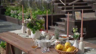 Renkli çiçekleri ve taze limonları olan güzel bir açık hava yemek masası. Bahar toplantıları için ideal.