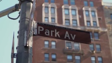 Park Avenue sokak tabelasının detaylı bir yakın çekim görüntüsü hareketli bir şehir arka planına güzel bir şekilde kurulmuş.