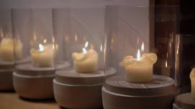 Huzurlu ve güzel bir mum sergisi, dikkatlice cam tutacaklarla kaplanmış, rahat bir ortam yaratıyor.