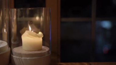 Huzurlu ve güzel bir mum sergisi, dikkatlice cam tutacaklarla kaplanmış, rahat bir ortam yaratıyor.