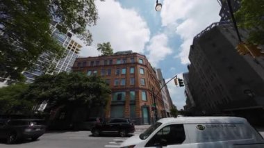 NEW YORK, ABD - 12 Mayıs 2024: Canlı bir şehir sahnesi bulutlu bir gökyüzü altında tarihi ve çağdaş mimarinin heyecan verici bir karışımını yakalıyor