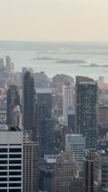 Nefes kesen panoramik manzara ikonik New York şehrinin siluetini sergiliyor, Empire State Binası ve One World Trade Center gibi simgelerle güzel, berrak bir gökyüzüne karşı