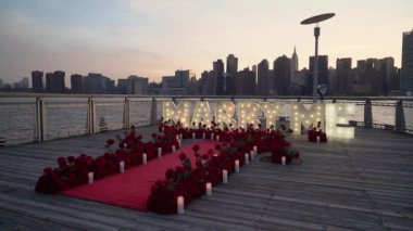 Romantik teklif, şehir siluetine karşı gül yapraklı ve mumlu 