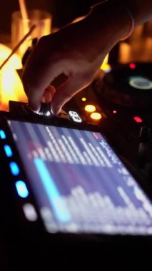 NEW YORK, ABD - 22 HAZİRAN 2024: Büyüleyici bir canlı şovda, bir DJ, renkli ışıklarla aydınlatılan, karıştırma ekipmanlarının ses ayarlarını ayarlamaya odaklanarak, büyüleyici bir atmosfer yaratmaya çalışır