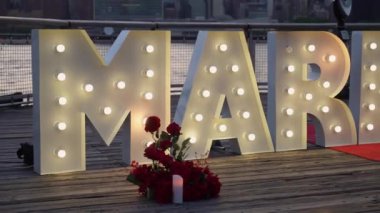 Romantik teklif, şehir siluetine karşı gül yapraklı ve mumlu 