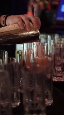 Profesyonel bir miksolog uzmanlığını, hareketli bir barda kokteyller hazırlayıp, misafirler için canlı bir ortam yaratarak ve canlı bir gece hayatı kurarak sergiliyor.