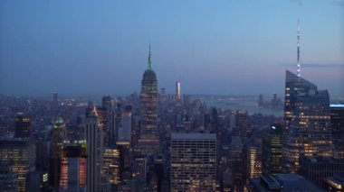 New York şehrinin ufuk çizgisi alacakaranlıkta nefes kesici bir manzara, Empire State Binası ve aydınlık gökdelenler, bu hareketli metropolün canlı özünü gözler önüne seriyor.