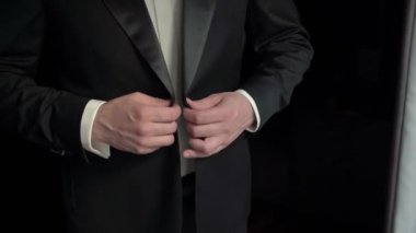 Klasik smokinli şık ve sofistike bir beyefendi zarif bir resmi etkinliğe titizlikle hazırlanır.