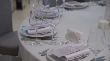 Lezzetli bir yemek deneyimi için nefis cam eşyalar ve zarif çatal bıçaklarla güzel bir yemek masası.
