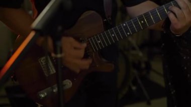 PSKOV, RUSSIA - 17 Temmuz 2024: Oldukça yetenekli bir müzisyen, canlı bir ortamda güzel bir ahşap elektro gitar çalar.