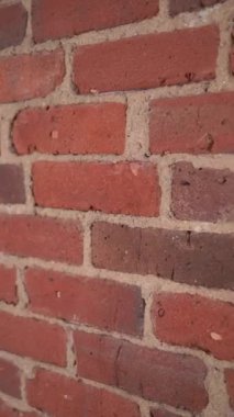 Kalıplaşmış tuğla bir duvarın yakın plan görüntüsü, çeşitli zengin renkler ve benzersiz desenler sergiliyor.