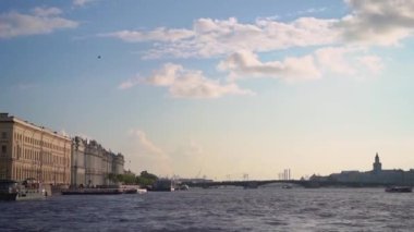 Küçük bir tekne, güneşli bir günde huzurlu ve sakin bir su yolunda yol alır. Saint-Petersburg 'da sakin bir manzara yaratır.