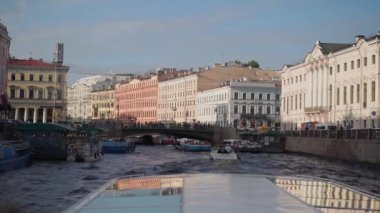 Saint-Petersburg 'daki manzaralı su yolu boyunca canlı binalar ve tekneler sergilenen büyüleyici bir kanal manzarası.