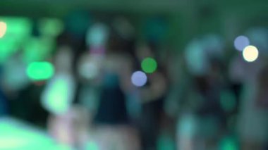 Bulanık ışıklarla dolu enerjik ve canlı bir parti atmosferi, hareketli bir kalabalık, ve gerçekten neşeli bir ortam.