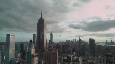 Empire State Binası 'nın çarpıcı ve dramatik manzarası kasvetli, bulutlu New York şehrinin siluetinin ortasında dikiliyor.