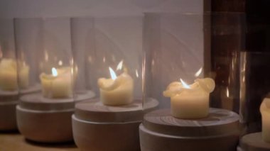 Huzurlu ve güzel bir mum sergisi, dikkatlice cam tutacaklarla kaplanmış, rahat bir ortam yaratıyor.