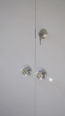 Temiz çizgilerle tasarlanmış minimalist bir odada bir çift kapalı beyaz dolap kapısı var.