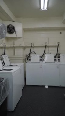 NEW YORK, ABD - 11 Kasım 2024: Hem uzay hem de zaman verimliliğini maksimuma çıkarmak için tasarlanmış istiflenebilir kurutma makinelerinin yer aldığı temiz, iyi korunmuş bir çamaşırhane