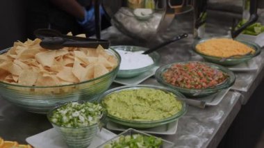 Unutulmaz bir toplantı için rengarenk bir tortilla cipsi, lezzetli guacamole ve malzemeler.