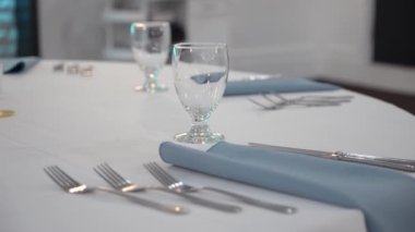 Güzel düzenlenmiş yemek seti, gösterişli şık masalar ve mavi ışıklarla aydınlatılmış şık bir bar.