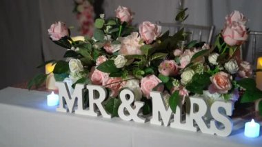 Zarif pembe ve beyaz güllerle çevrili büyüleyici Bay Bayan işareti, her romantik düğün için mükemmel bir gösteri yaratıyor ve kalbi gerçekten büyülüyor.