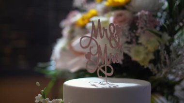 Bu çarpıcı düğün pastasında zarif bir Bay ve Bayan Topper ve güzel düzenlenmiş çiçekler var. Özel gününüzde aşkı ve birlikteliği kutlamak için mükemmel bir süs.