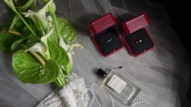 PSKOV, RUSSIA - 17 Temmuz 2024: Düğün ayrıntıları bir masa üzerinde düzenlenmiş çarpıcı buket, dekoratif kutular ve zarif parfüm içerir