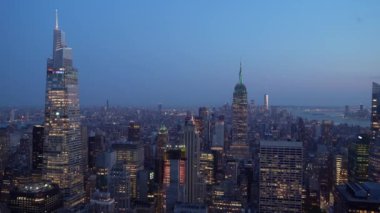 New York şehrinin ufuk çizgisi alacakaranlıkta nefes kesici bir manzara, Empire State Binası ve aydınlık gökdelenler, bu hareketli metropolün canlı özünü gözler önüne seriyor.