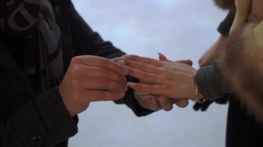 Bir çift, birbirlerine olan derin sevgilerini ve bağlılıklarını simgeleyen hassas bir anda güzel bir yüzüğü değiş tokuş ediyor.