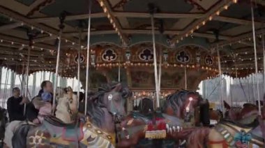 NEW YORK, ABD - 10 Kasım 2024: Karmaşık bir şekilde tasarlanmış ve ahşap atları büyüleyen güzel aydınlatılmış bir klasik atlıkarınca